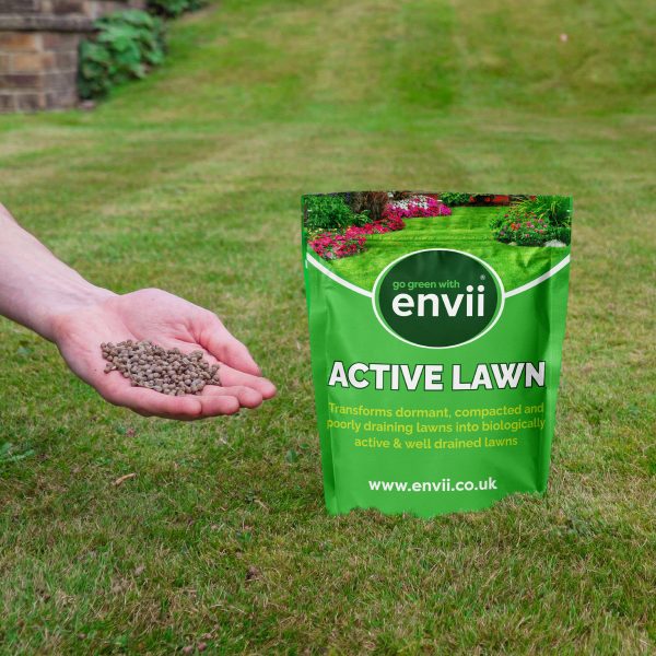 Active Lawn situated on grass with hand holding the product to apple directly to the lawn.